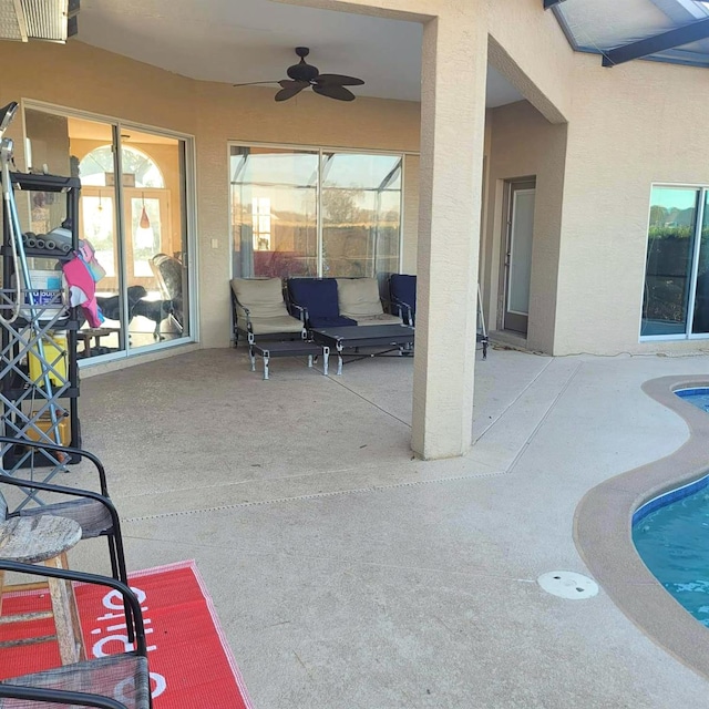 view of patio with ceiling fan and a swimming pool