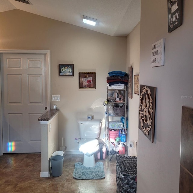 bathroom with tile patterned floors and lofted ceiling