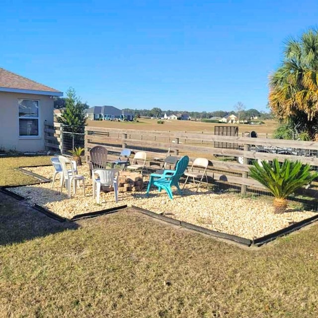 view of yard featuring a rural view and a fire pit