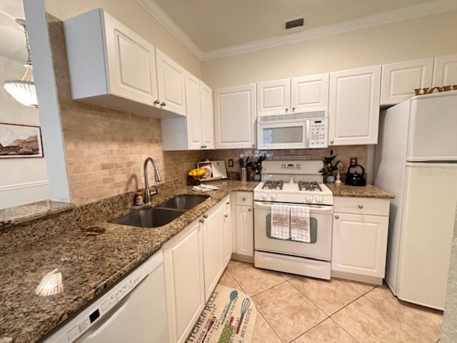 kitchen featuring white appliances, dark stone counters, sink, tasteful backsplash, and white cabinetry