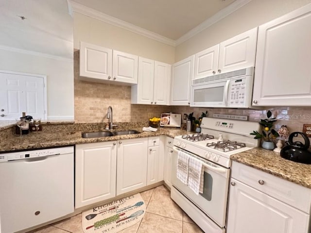 kitchen featuring stone counters, white cabinetry, sink, white appliances, and light tile patterned floors