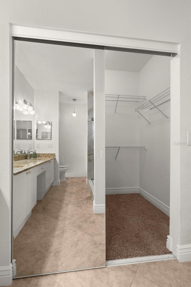 bathroom featuring tile patterned floors, vanity, and toilet