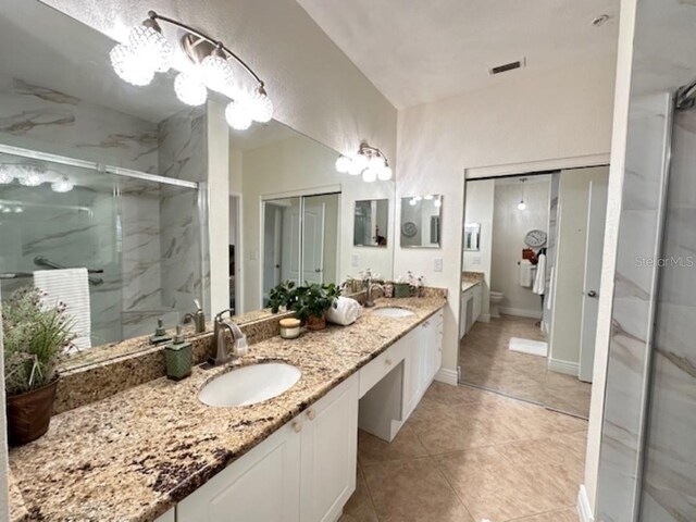 bathroom featuring tile patterned floors, vanity, and a shower with door