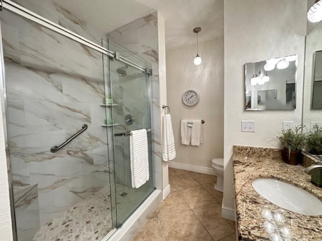 bathroom with tile patterned flooring, vanity, toilet, and walk in shower