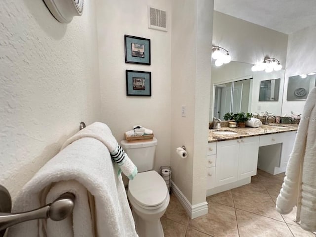 bathroom featuring tile patterned flooring, vanity, toilet, and an AC wall unit