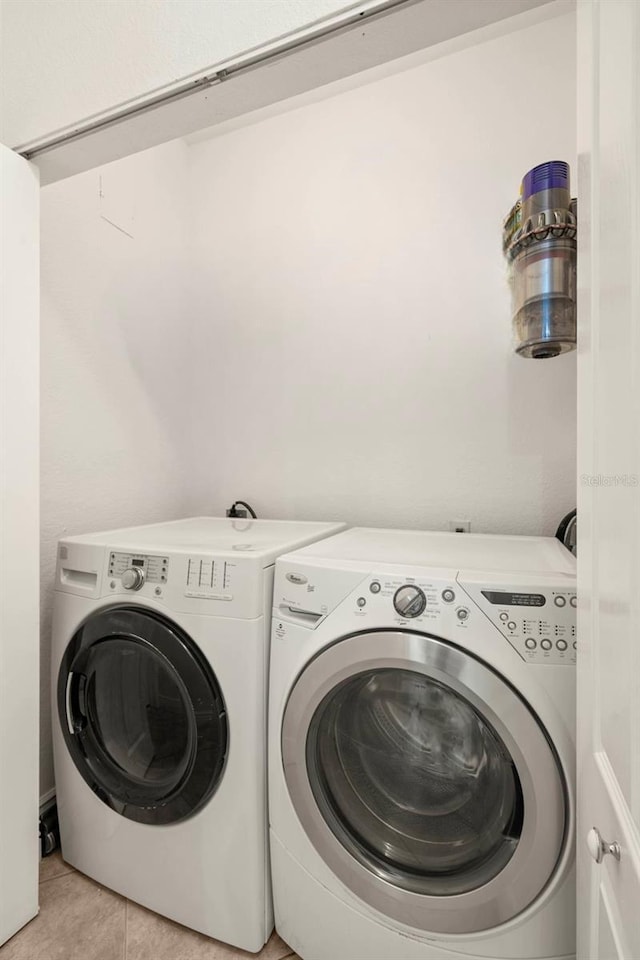 clothes washing area with light tile patterned floors and separate washer and dryer