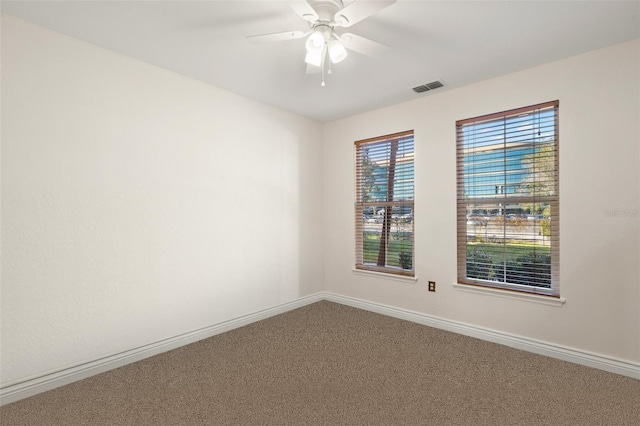 carpeted spare room with ceiling fan