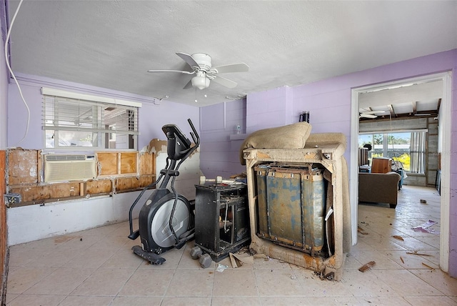 interior space with ceiling fan, cooling unit, and a textured ceiling