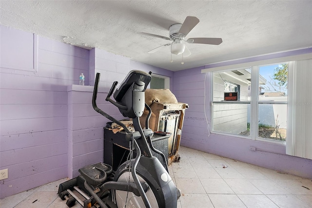 exercise room featuring ceiling fan, a textured ceiling, and a wealth of natural light