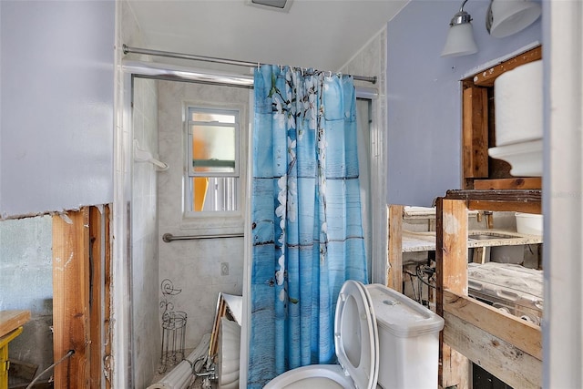 bathroom with a shower with curtain and toilet