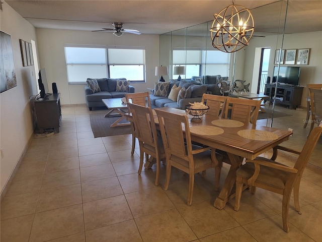 dining room with light tile patterned floors and ceiling fan with notable chandelier