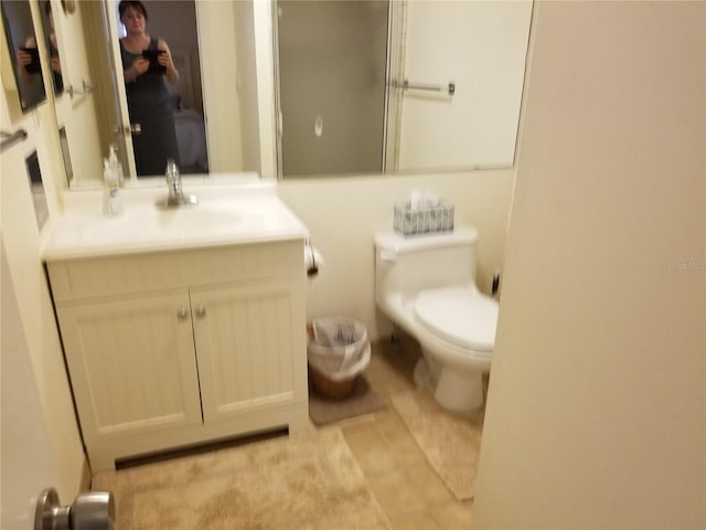 bathroom featuring tile patterned flooring, vanity, and toilet