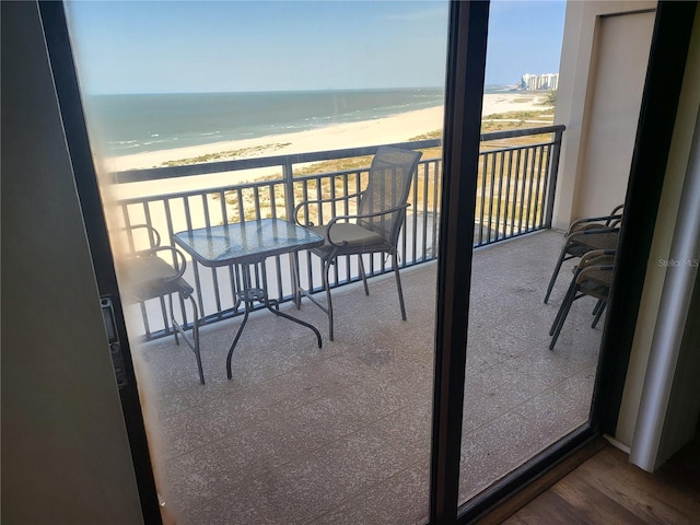 balcony featuring a water view and a beach view