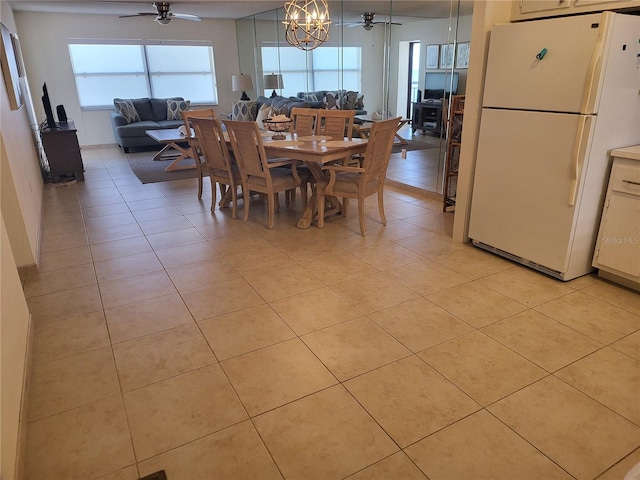 tiled dining room featuring ceiling fan with notable chandelier