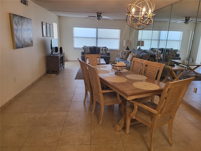 tiled dining room with ceiling fan with notable chandelier