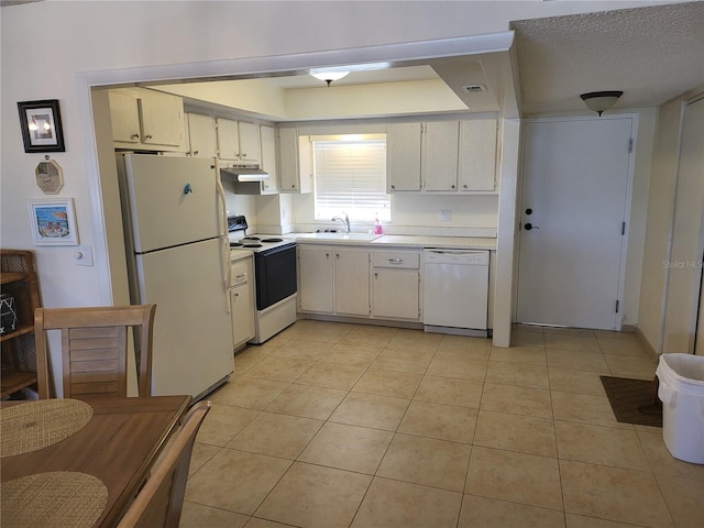 kitchen featuring a textured ceiling, light tile patterned flooring, white appliances, and sink