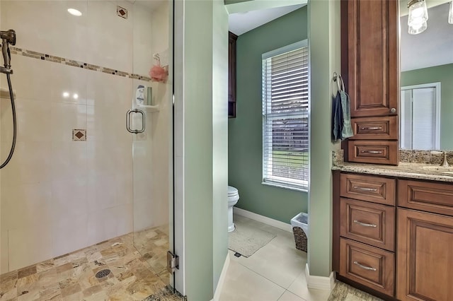 bathroom with tile patterned floors, vanity, toilet, and a shower with shower door