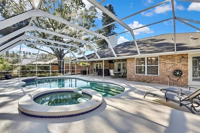 view of pool featuring glass enclosure, an in ground hot tub, a patio area, and ceiling fan