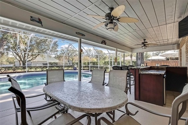 view of patio with a lanai, exterior bar, and a fenced in pool