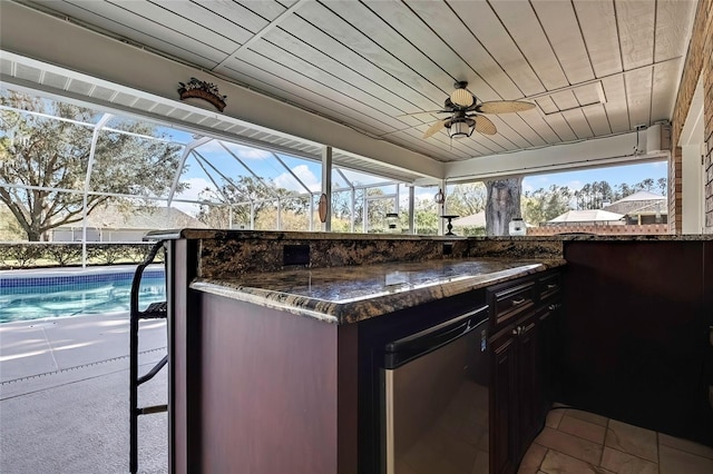 view of patio with glass enclosure and a bar