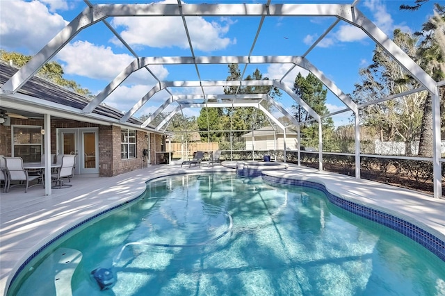 view of swimming pool with french doors, a patio, and a lanai