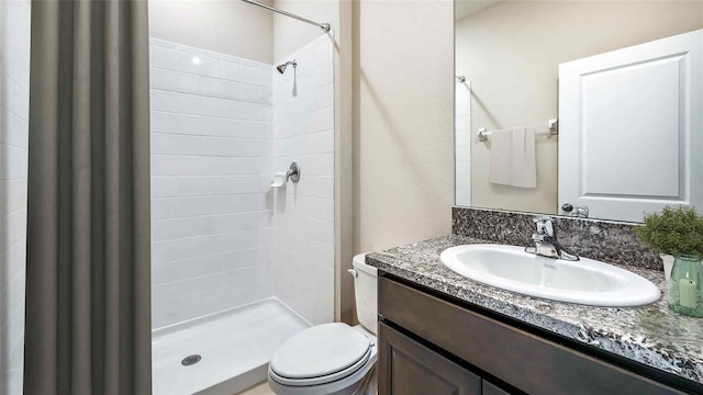 bathroom with vanity, toilet, and a shower