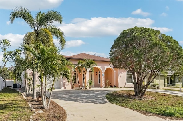 mediterranean / spanish home featuring a garage and a front lawn