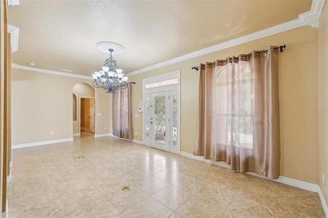 spare room featuring ornamental molding, a textured ceiling, and an inviting chandelier