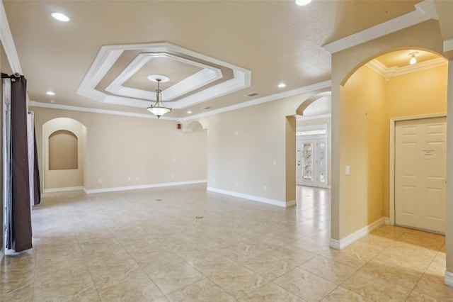 spare room with a tray ceiling and ornamental molding