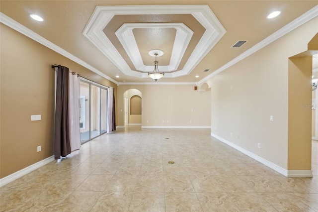 unfurnished room featuring ornamental molding and a tray ceiling