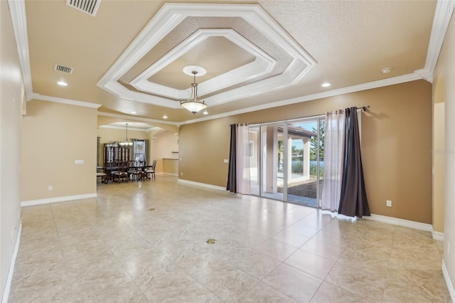 unfurnished room featuring a tray ceiling, a notable chandelier, and ornamental molding