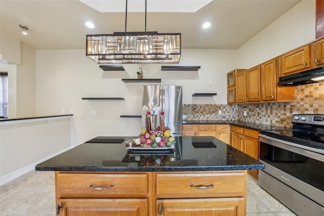 kitchen with backsplash, dark stone countertops, a kitchen island, and stainless steel appliances