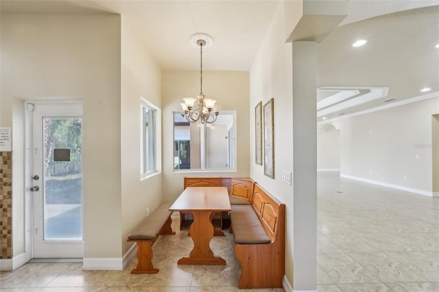 tiled dining room featuring ornamental molding and a chandelier