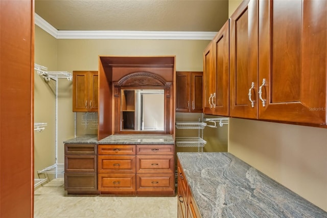 kitchen with crown molding, light tile patterned floors, and stone countertops