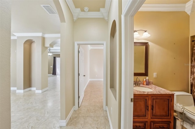 hallway featuring crown molding, sink, and light tile patterned floors