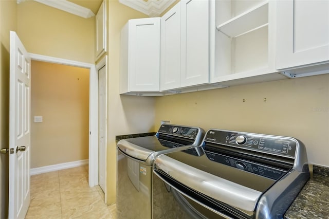 washroom featuring separate washer and dryer, light tile patterned flooring, and cabinets