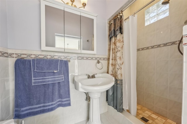 bathroom featuring curtained shower and tile walls