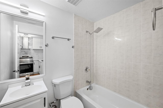 full bathroom featuring backsplash, a textured ceiling, vanity, toilet, and tiled shower / bath