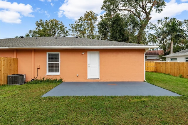 back of property with a lawn, a patio area, and central air condition unit