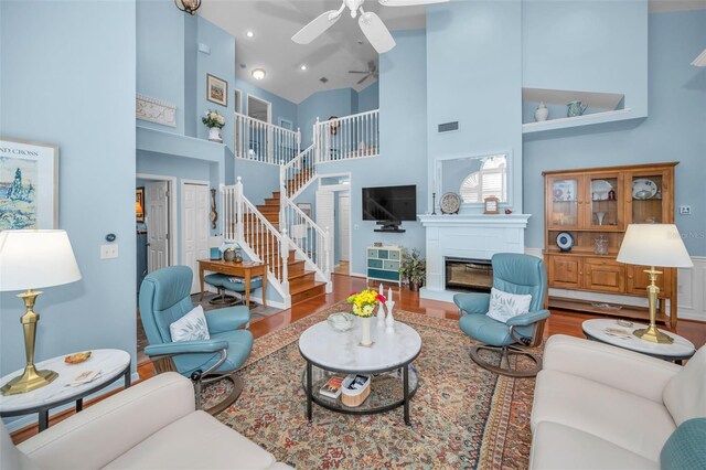 living room featuring ceiling fan, high vaulted ceiling, and wood-type flooring