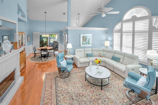 living room featuring ceiling fan, light hardwood / wood-style flooring, and high vaulted ceiling