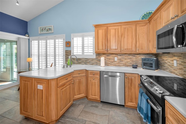 kitchen with sink, stainless steel appliances, backsplash, kitchen peninsula, and lofted ceiling