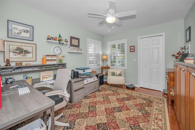 home office featuring hardwood / wood-style floors, a textured ceiling, and ceiling fan