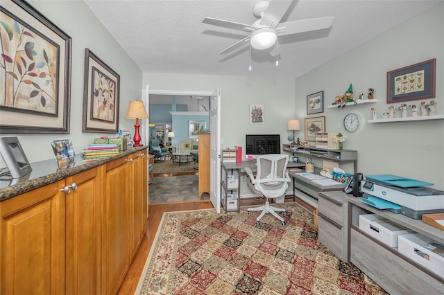 home office featuring ceiling fan, a textured ceiling, and light wood-type flooring