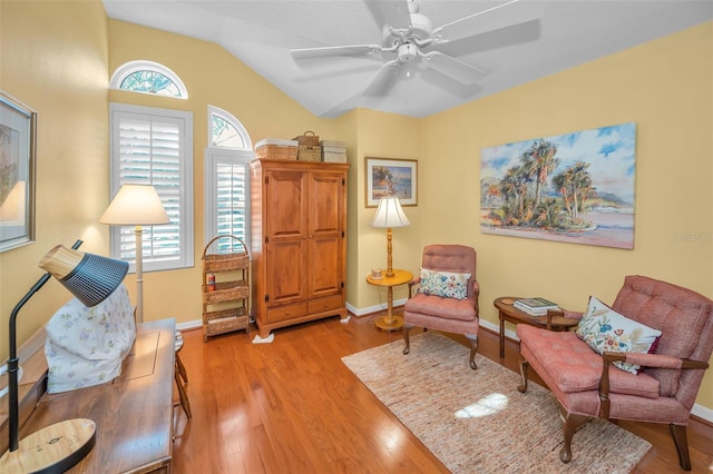 living area featuring a wealth of natural light, light hardwood / wood-style flooring, ceiling fan, and lofted ceiling