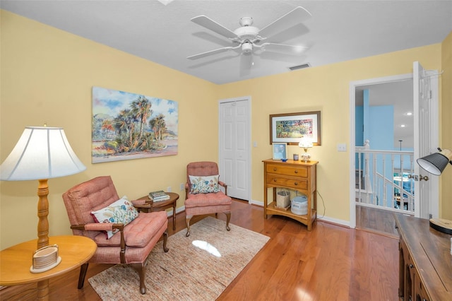 living area with ceiling fan and light wood-type flooring