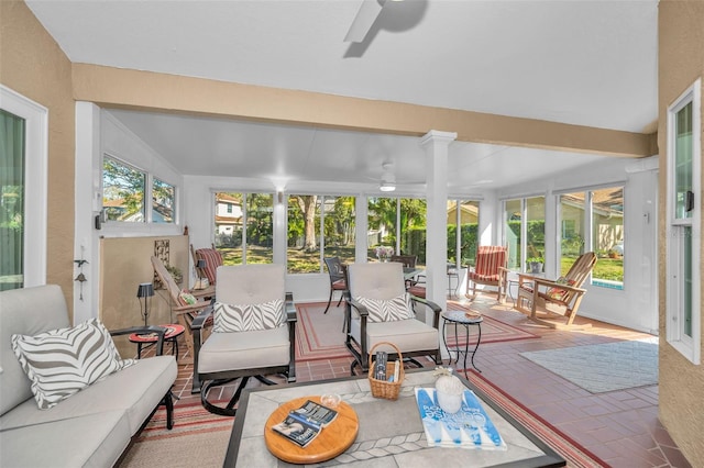 sunroom featuring vaulted ceiling with beams, ceiling fan, and a healthy amount of sunlight