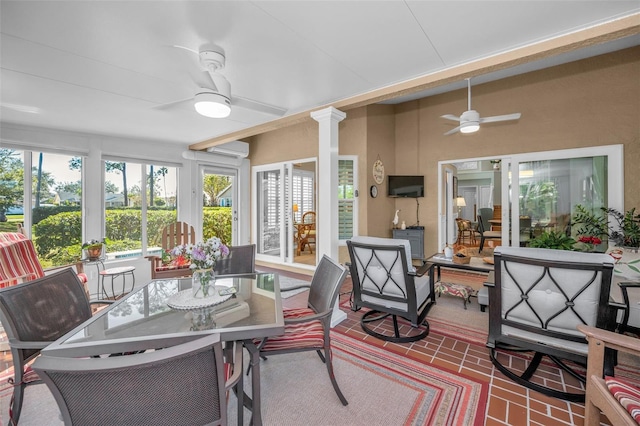 sunroom / solarium with ceiling fan, ornate columns, and an AC wall unit