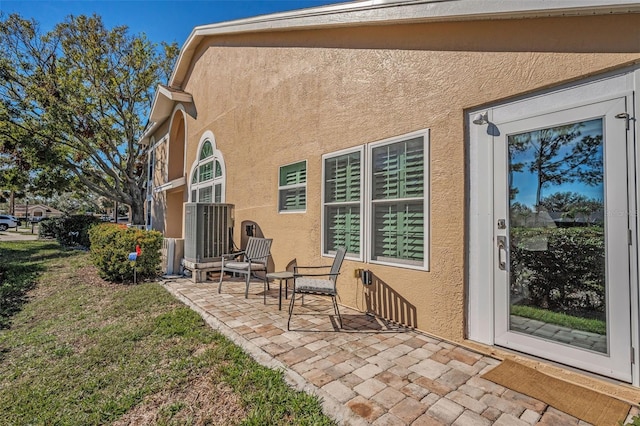 back of property featuring a lawn, a patio area, and central air condition unit