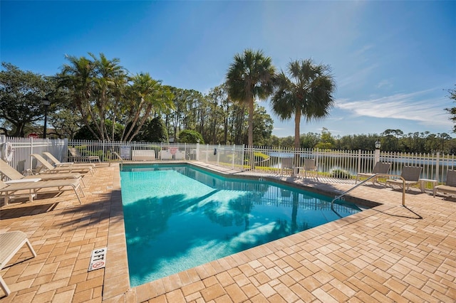 view of swimming pool with a water view and a patio area